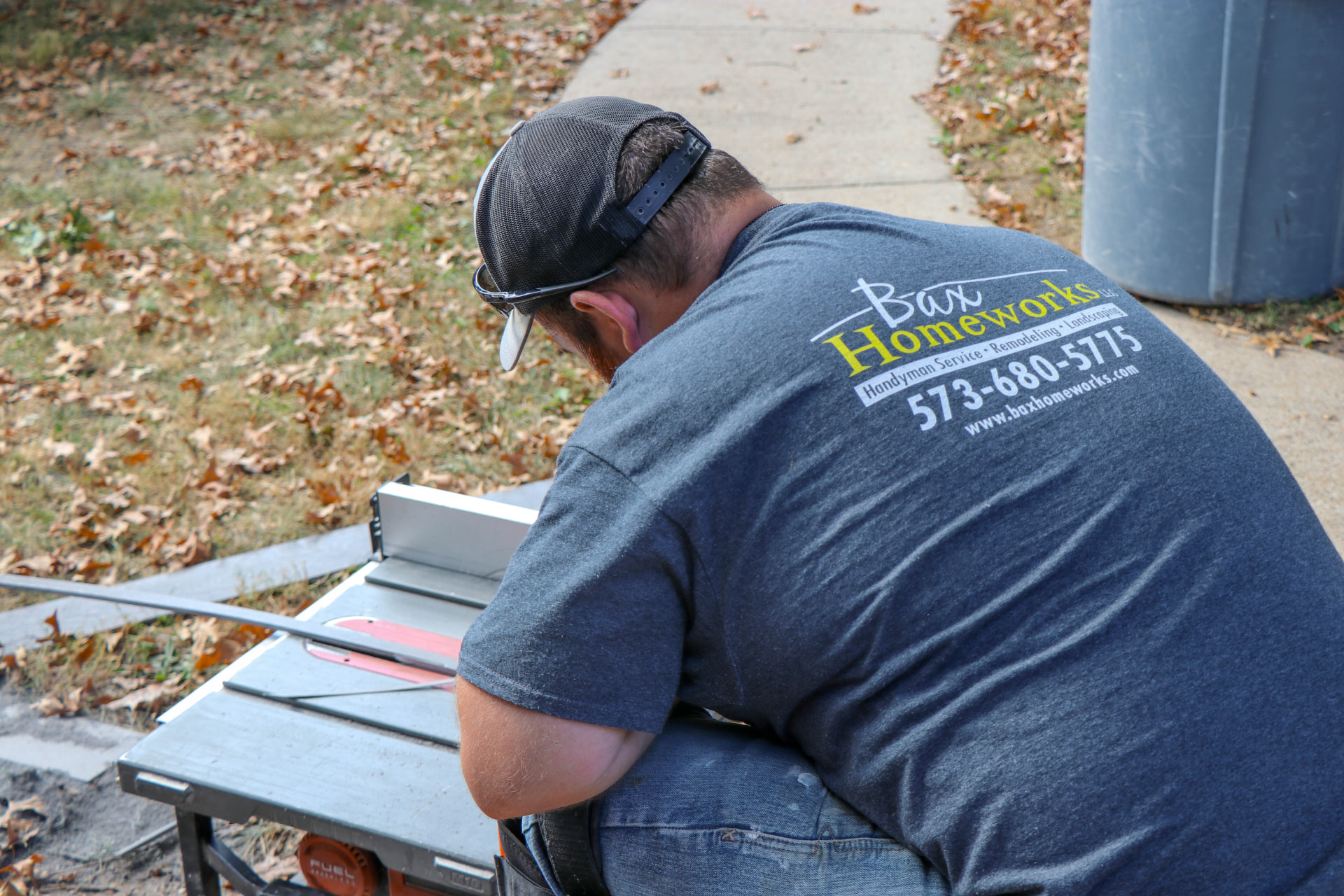Bax Homeworks crew member cutting trim on a jobsite table saw